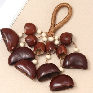 Detailed close-up of handmade nut shell pendant with polished brown seeds and woven rope