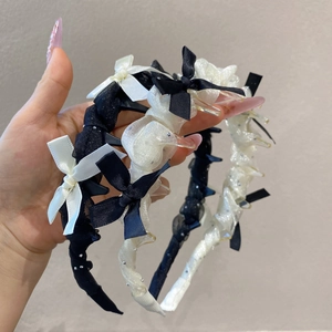 Détail du serre-tête en dentelle avec perles et petites pinces pour fixer la coiffure
