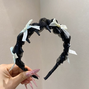 Détail du serre-tête en résille avec nœuds en satin et pinces à cheveux intégrées