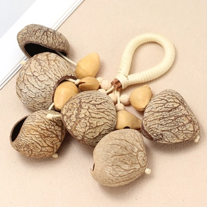 Detail of handcrafted nut shell rattle with woven cotton rope and natural wood beads