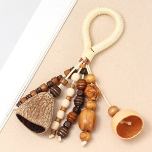 Macro detail of handmade wooden bead pendant with natural shell rattles and woven strap