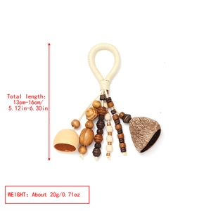 Detail of bohemian handmade nut shell charm with wooden beads and woven cord hanging