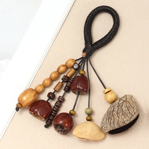 Detail of handmade ethnic instrument with natural nut shells and woven rope handle