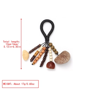 Detail of handmade ethnic pendant with natural nut shells and woven rope tassels