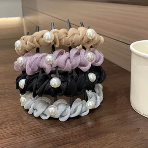 Close-up of four pearl mesh scrunchies in gold, purple, black, and gray on a desktop
