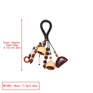 Detailed view of handmade nut shell tassel charm with colorful ethnic beads and rope
