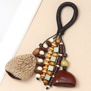 Detail of handcrafted ethnic charm with natural seeds, wooden beads and polished pendant