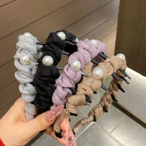 Detail showing non-slip plastic inner teeth and faux pearls on woven headbands