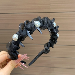 Dettaglio del cerchietto in tulle nero con perle e denti antiscivolo per una tenuta sicura