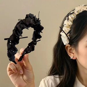 Detailed close-up of beige polka dot pleated headband with vintage style bow detail