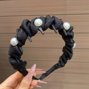 Close-up of black shimmer headband with large faux pearls and anti-slip inner teeth