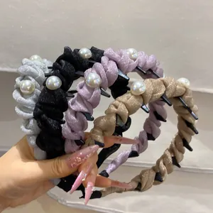 Detailed view of four pleated fabric headbands with faux pearls and inner anti-slip teeth