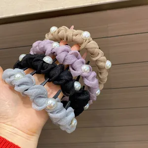 Detail of twisted fabric hair clips with pearls in champagne, violet, black and silver grey