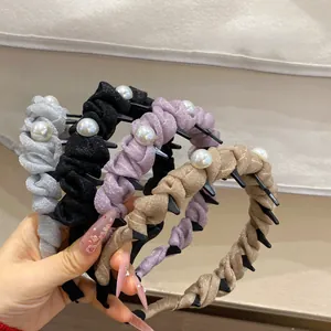 Detail view of four velvet pearl headbands in grey, black, purple and champagne