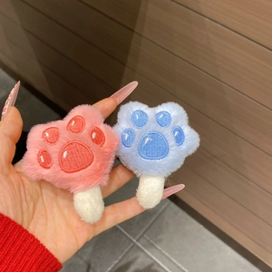 Nahaufnahme von rosa und blauen Plüsch-Katzenpfoten-Haarspangen mit feiner Stickerei