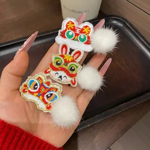 Three-piece Chinese New Year hair clips with embroidered lion and rabbit and white pom-poms