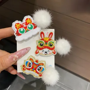 Close-up of Chinese New Year embroidery hair clips with lion dance and rabbit motifs