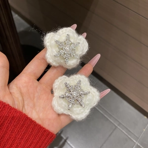 Close-up of winter snowflake hair clips with white plush knit and sparkling rhinestones