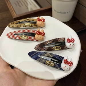Detail of four plaid rabbit hair clips set with cute 3D bunnies in a ceramic tray