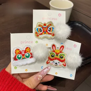 Detailed embroidery of Chinese New Year tiger, lion, and rabbit hair clips with plush balls