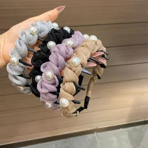 Detailed view of four pearl-embellished headbands with non-slip teeth for hair styling