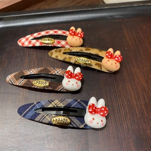Detail view of plaid and leopard print fabric BB hair clips with cute resin bunnies