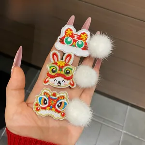 Close-up of Chinese New Year hair clips with embroidered lion, rabbit and tiger motifs