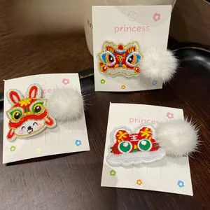 Close-up of Chinese New Year embroidery hair clips with cute rabbit and lion motifs