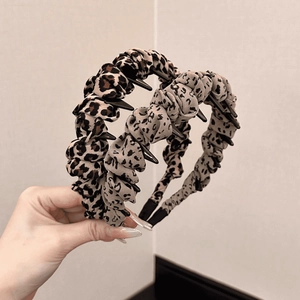 Detailed view of leopard print pleated fabric headbands with non-slip inner teeth