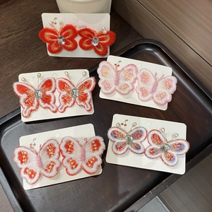 Détail de cinq paires de barrettes papillon brodées avec perles et strass brillants