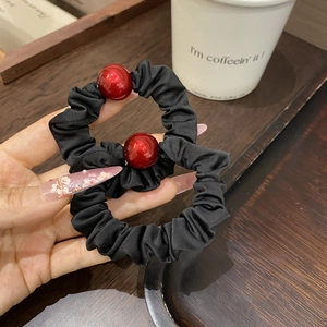 Elegant black scrunchie set with red bead accents for stylish ponytail and bun hairstyles