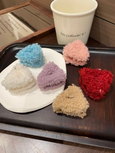 Sei fermagli triangolari per capelli in peluche colorati su un vassoio elegante