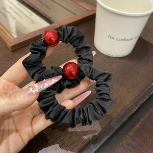 Elegant black fabric scrunchie set with vibrant red bead accents for stylish ponytail styles
