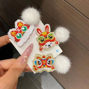 Detail of embroidered New Year hair clips with lion dance and rabbit motifs on wood