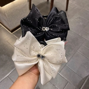 Détail de pinces à cheveux en satin avec strass argentés et gemmes en forme de cœur