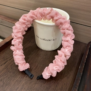 Rosa faltiges Stoffstirnband mit gewellter Textur und rutschfesten Zähnen auf Keramiktasse