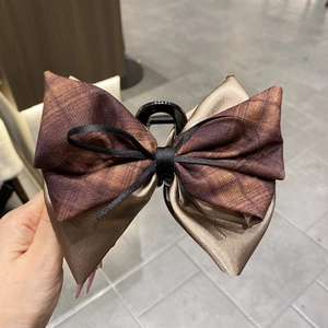 Detail of 13cm dark brown plaid ribbon bow hair claw clip with elegant satin texture