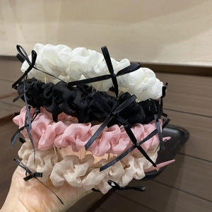 Gros plan de quatre serre-têtes en tissu ondulé avec des nœuds noirs en plusieurs couleurs