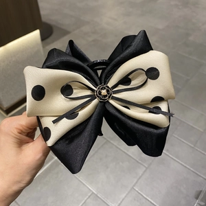 Detail of 13cm oversized hair claw with polka dot ribbon bow and camellia pearl