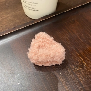 Dettaglio di un fermaglio per capelli in peluche rosa a forma di cuore su vassoio