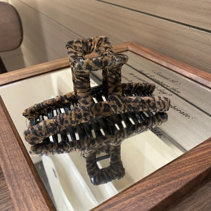 Nahaufnahme einer großen Haarklammer mit Leopardenmuster auf einer Spiegeloberfläche