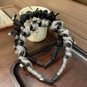 Detail of twisted fabric headbands with rhinestones in black and silver grey colors