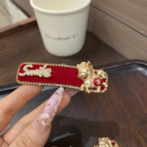 Nahaufnahme der roten Samthaarspange mit Glitzersteinen und goldenem Pferdemotiv