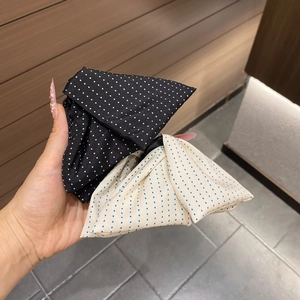 Detail of large polka dot fabric shark hair claws in black and cream with pleated layers