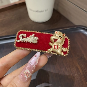 Detail der roten Samt-Haarklammer mit Smile-Schriftzug und goldenem Pferdemotiv für Neujahr