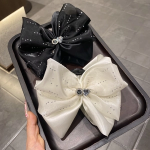 Détail de pinces à cheveux à nœud en seersucker avec strass brillants et cristaux de cœur