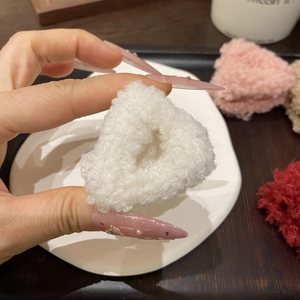 Dettaglio della piccola molletta per capelli a triangolo in peluche bianco
