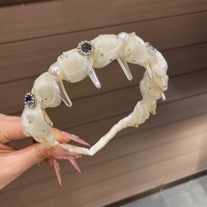 Detailed close-up of non-slip headband with cream mesh, faux pearls and rhinestone flowers