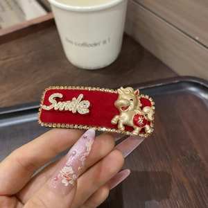 Detail der roten Samt-Haarklammer mit Strass, goldenem Pferd und Smile-Schriftzug
