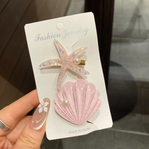 Glitzernde rosa Seestern und Muschel Haarspangen mit Perlen auf einer Displaykarte